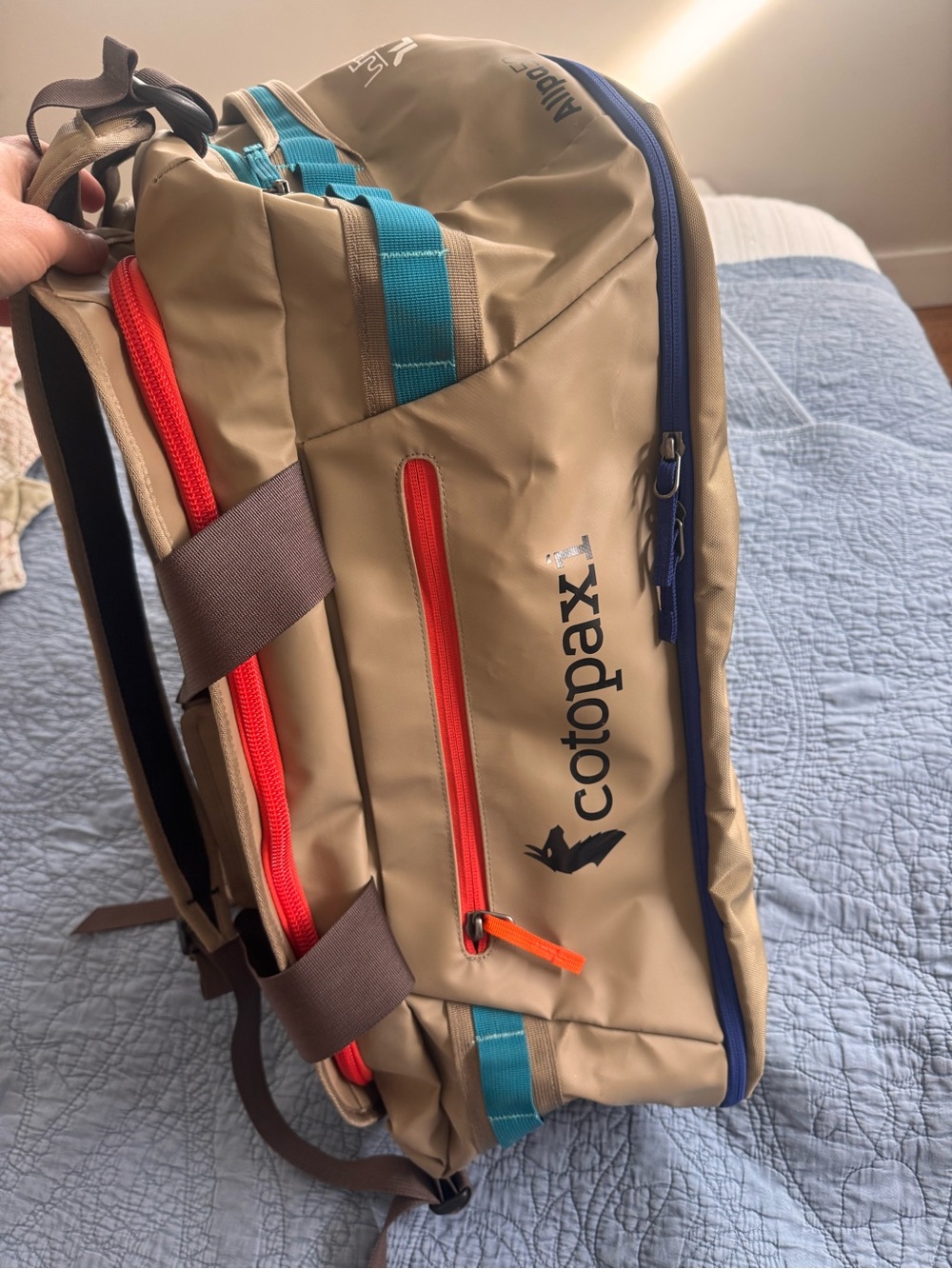 cotopaxi tan backpack with blue and orange trim